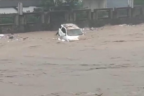 Un auto es arrastrado por la corriente de un río en China