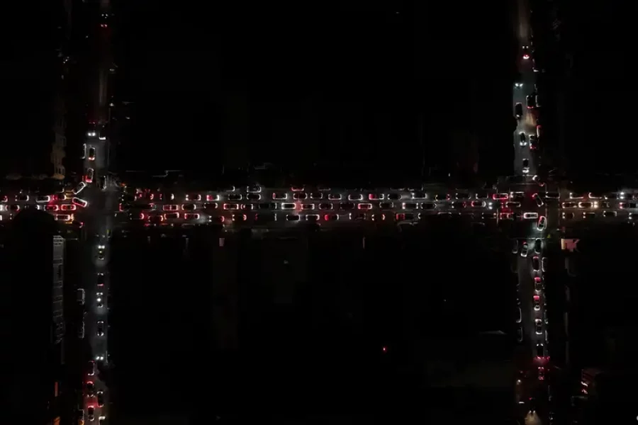 Imagen aérea de las calles, sólo iluminadas por las luces de los automóbiles.